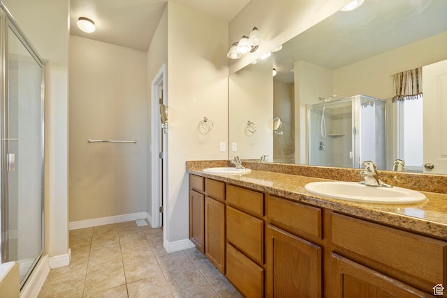 bathroom featuring a sink, tile patterned floors, and a shower stall