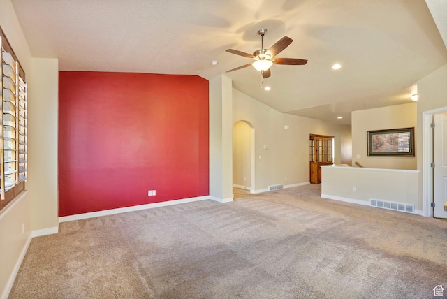 unfurnished living room featuring vaulted ceiling, visible vents, arched walkways, and a ceiling fan