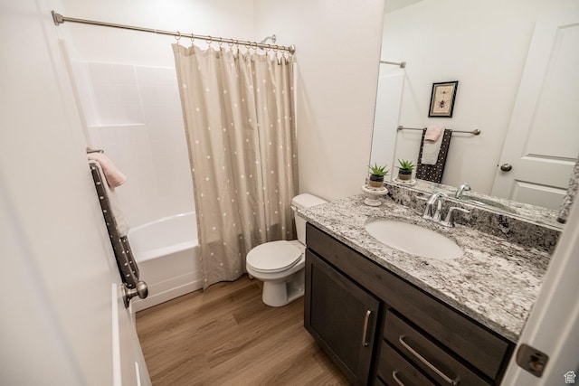 bathroom with toilet, wood finished floors, shower / tub combo with curtain, and vanity