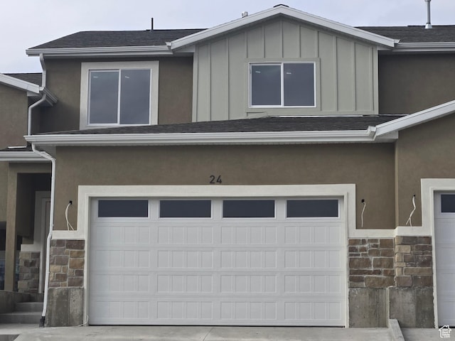 exterior space with stone siding and an attached garage