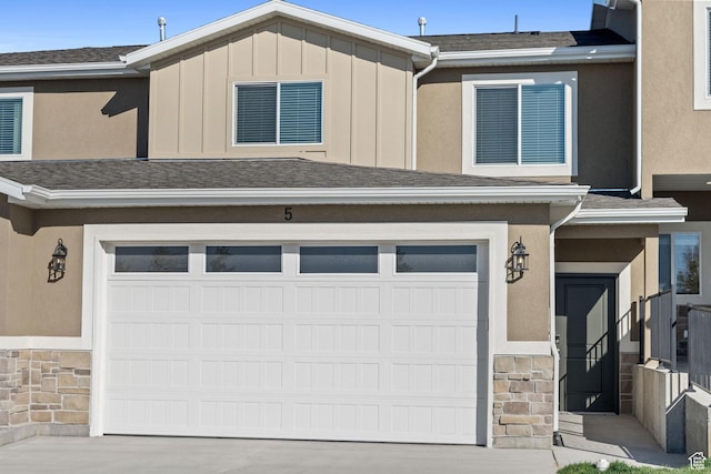 213 E 535 N Unit 30, Richmond, UT 84333 - view of property with a garage, stone siding, concrete driveway, and board and batten siding