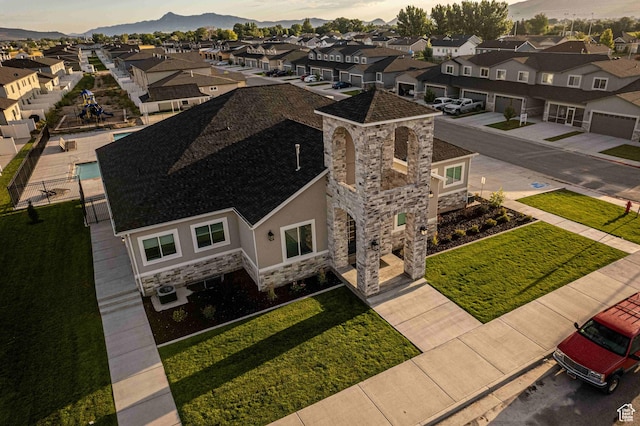 aerial view at dusk featuring a residential view and a mountain view