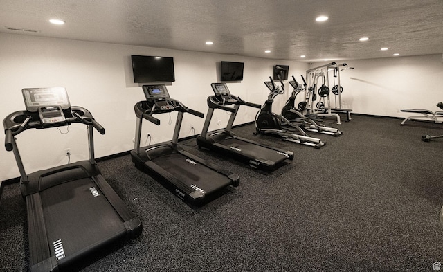 exercise room with baseboards, recessed lighting, and a textured ceiling