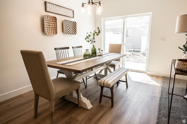 dining room featuring baseboards, wood finished floors, and a chandelier