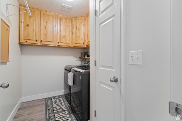 1519 N 2340 W, Clinton, UT 84015 - laundry room with washing machine and clothes dryer, visible vents, baseboards, light wood-type flooring, and cabinet space