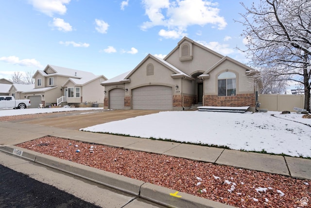 1519 N 2340 W, Clinton, UT 84015 - view of front of house featuring fence, a garage, concrete driveway, brick siding, and stucco siding