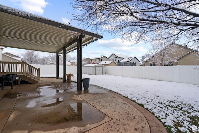 1519 N 2340 W, Clinton, UT 84015 - snowy yard with a fenced backyard, a storage unit, a residential view, an outbuilding, and a patio area