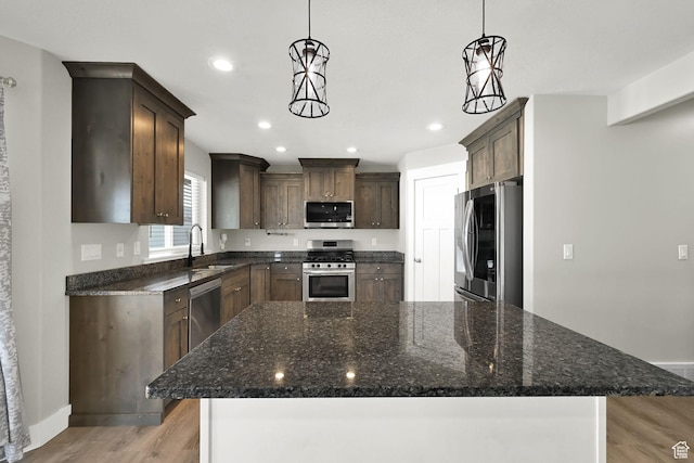 2466 W 3375 S, West Haven, UT 84401 - kitchen with dark brown cabinets, appliances with stainless steel finishes, dark stone countertops, a sink, and light wood-type flooring