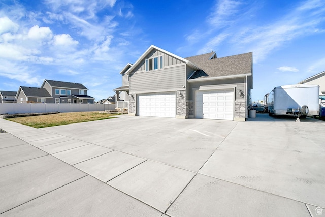 2466 W 3375 S, West Haven, UT 84401 - view of property exterior with stone siding, concrete driveway, fence, board and batten siding, and a garage