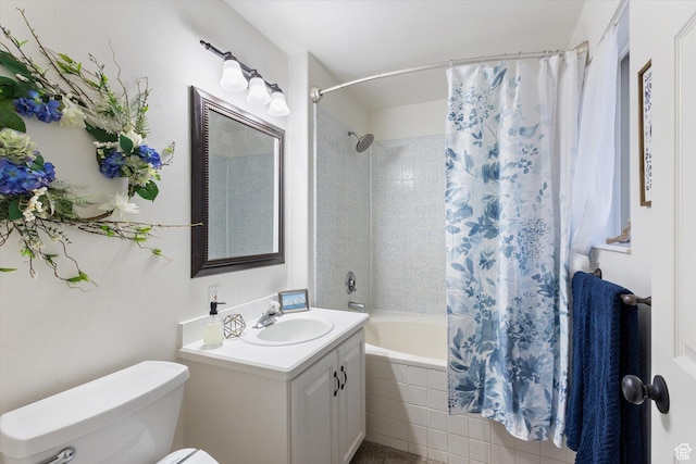 bathroom featuring toilet, vanity, and tiled shower / bath