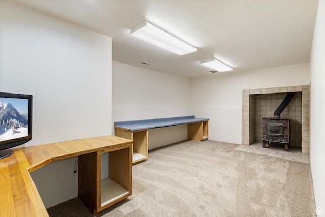 unfurnished office with carpet floors and a wood stove