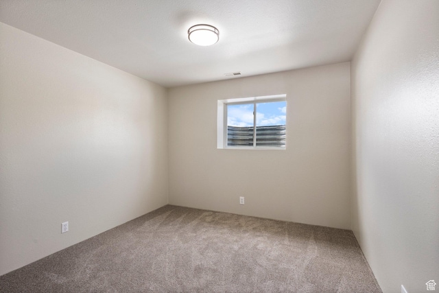 carpeted spare room featuring visible vents