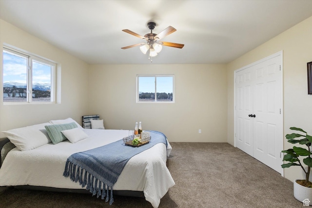 bedroom with a closet, ceiling fan, and carpet flooring