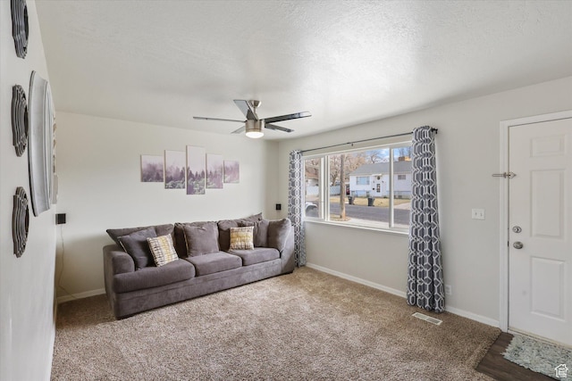 living room featuring baseboards, visible vents, ceiling fan, and carpet