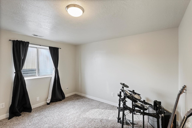 misc room with baseboards, visible vents, carpet flooring, and a textured ceiling