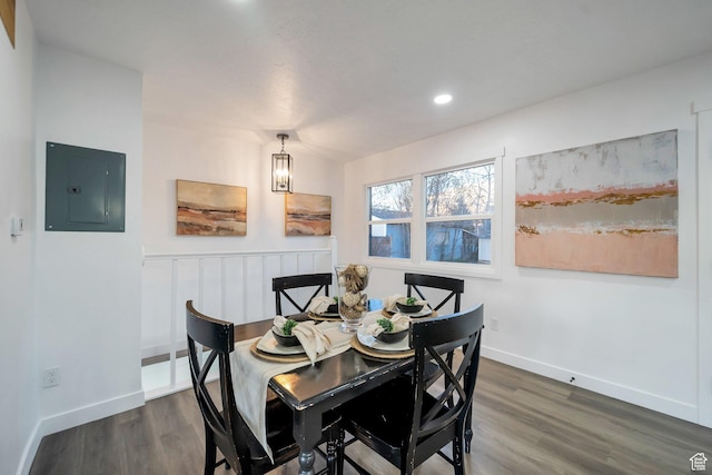 dining room with electric panel, baseboards, and dark wood-style flooring