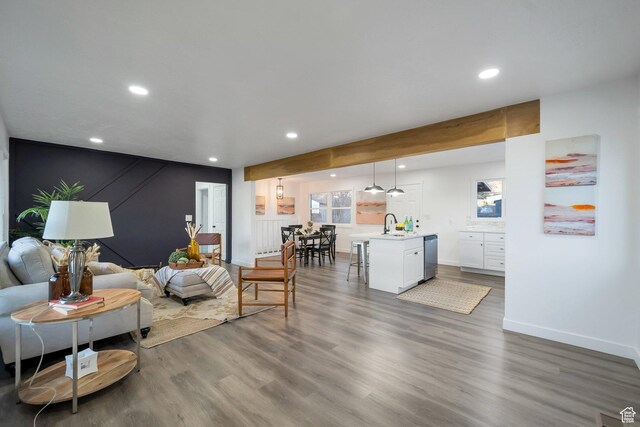 living area with baseboards, wood finished floors, and recessed lighting