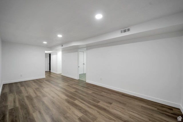 finished below grade area with recessed lighting, dark wood-style floors, baseboards, and visible vents