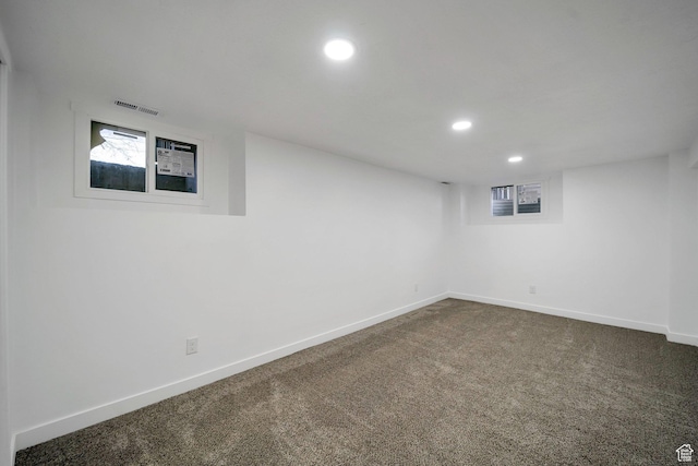 finished basement featuring baseboards, visible vents, dark carpet, and recessed lighting