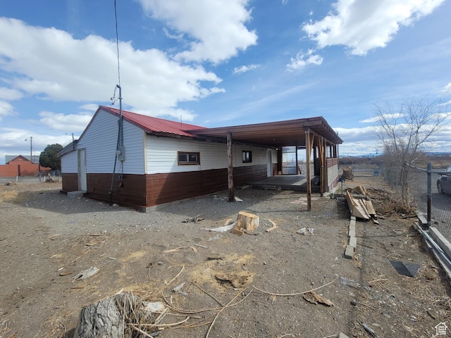250 8th St, Wendover, UT 84083 - back of property featuring an attached carport, fence, and metal roof