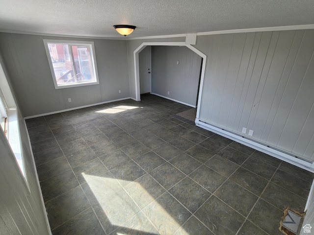 250 8th St, Wendover, UT 84083 - unfurnished room featuring ornamental molding, baseboards, a textured ceiling, arched walkways, and a baseboard radiator