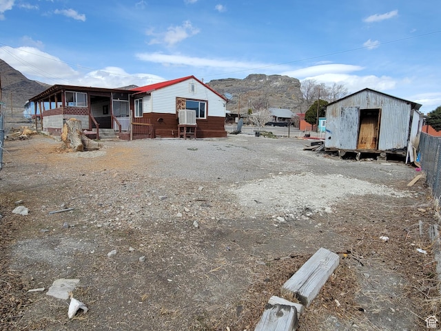 250 8th St, Wendover, UT 84083 - view of yard featuring an outbuilding, a storage unit, fence, and a mountain view