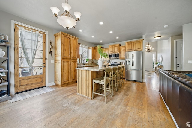 1637 E 2400 N, Layton, UT 84040 - kitchen with an inviting chandelier, light wood-style floors, a kitchen island, and appliances with stainless steel finishes