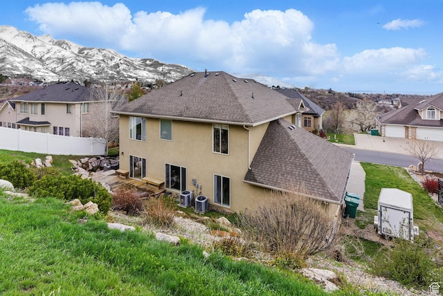 1637 E 2400 N, Layton, UT 84040 - rear view of property featuring central AC, roof with shingles, stucco siding, fence, and a mountain view