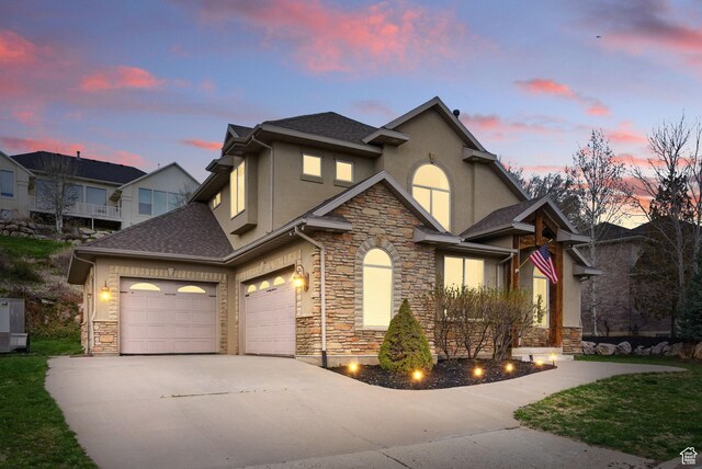 1637 E 2400 N, Layton, UT 84040 - view of front of home featuring stone siding, concrete driveway, stucco siding, and an attached garage