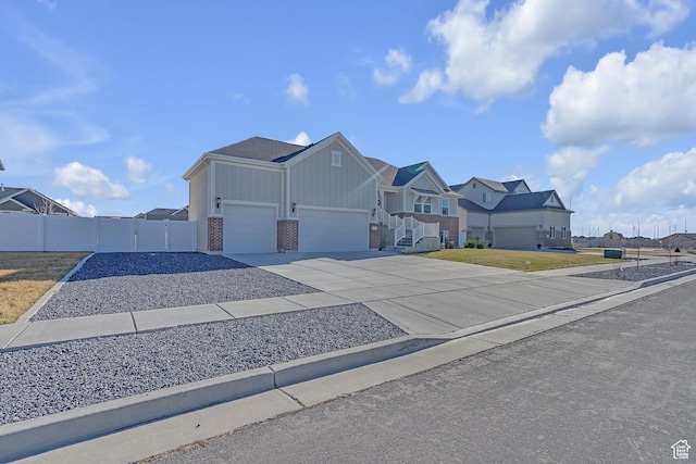 3457 W Blue Crane Dr N, Clinton, UT 84015 - view of front of property with board and batten siding, brick siding, concrete driveway, an attached garage, and a gate
