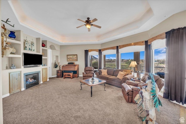 799 N 2600 W, Hurricane, UT 84737 - living area with a tray ceiling, carpet flooring, a fireplace with flush hearth, a ceiling fan, and built in features