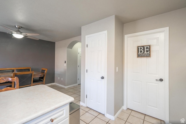 1301 W Indian Hills Dr Unit 59, St George, UT 84770 - kitchen featuring white cabinetry, light countertops, light tile patterned flooring, arched walkways, and a ceiling fan