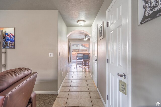 1301 W Indian Hills Dr Unit 59, St George, UT 84770 - corridor with light tile patterned flooring, a textured ceiling, baseboards, and arched walkways
