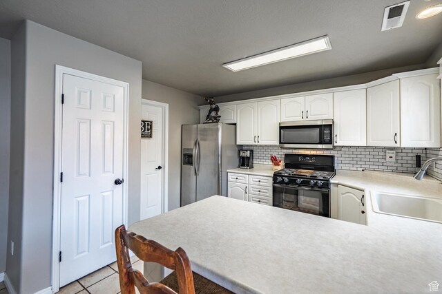 1301 W Indian Hills Dr Unit 59, St George, UT 84770 - kitchen with a sink, appliances with stainless steel finishes, light tile patterned floors, visible vents, and decorative backsplash