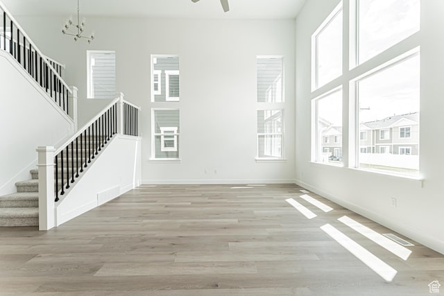 3877 W 950 N Unit 367, Lehi, UT 84043 - unfurnished living room with stairway, healthy amount of natural light, a chandelier, and wood finished floors
