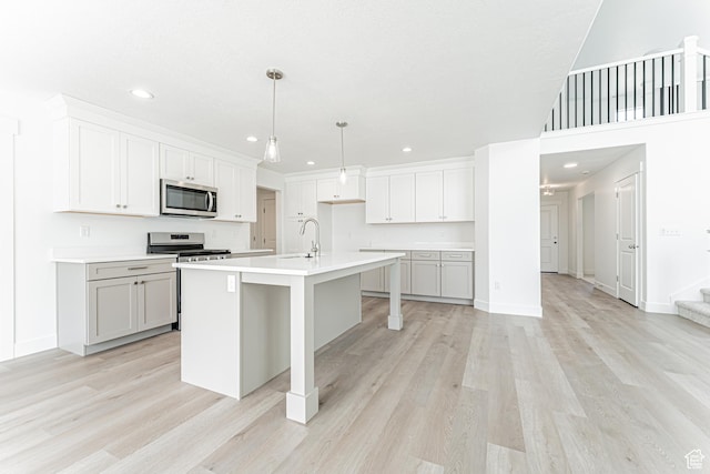 3877 W 950 N Unit 367, Lehi, UT 84043 - kitchen featuring appliances with stainless steel finishes, light wood-style flooring, recessed lighting, light countertops, and a center island with sink