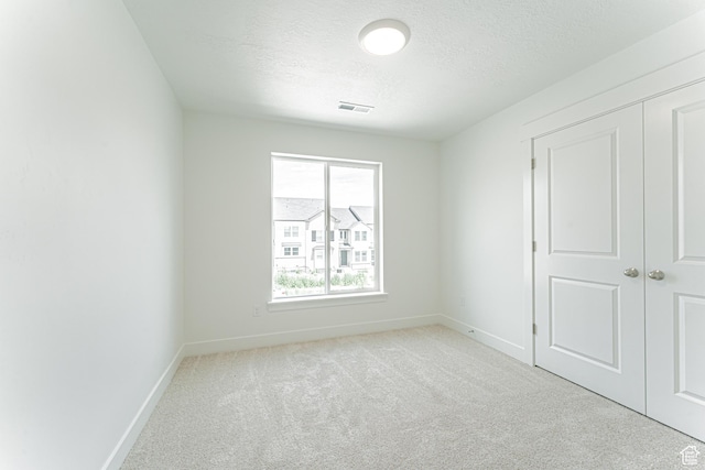 3877 W 950 N Unit 367, Lehi, UT 84043 - unfurnished bedroom with light carpet, a textured ceiling, and a closet