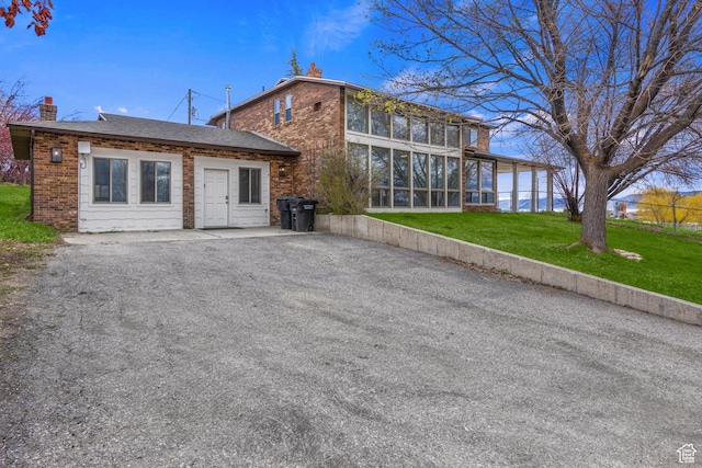 199 N 300 W, Garden City, UT 84028 - back of house with a chimney, brick siding, a sunroom, and a lawn