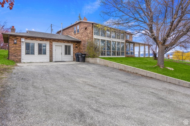 199 N 300 W, Garden City, UT 84028 - exterior space featuring a chimney, brick siding, a sunroom, and a lawn