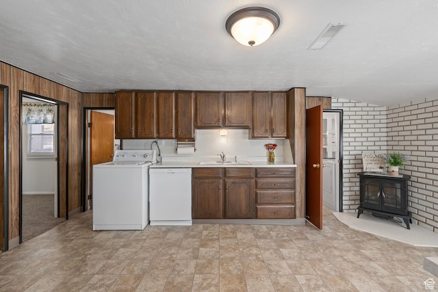 kitchen featuring light countertops, washer / clothes dryer, a sink, visible vents, and dishwasher