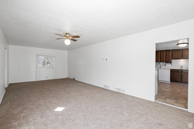 unfurnished living room with a sink, ceiling fan, visible vents, and light carpet