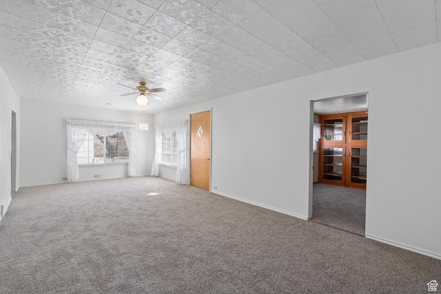 unfurnished living room featuring baseboards, carpet floors, and ceiling fan