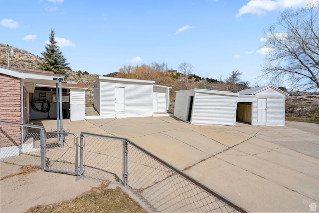 exterior space featuring a storage unit, a gate, and fence