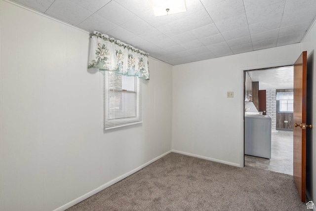 unfurnished room with baseboards, carpet flooring, and washer / clothes dryer