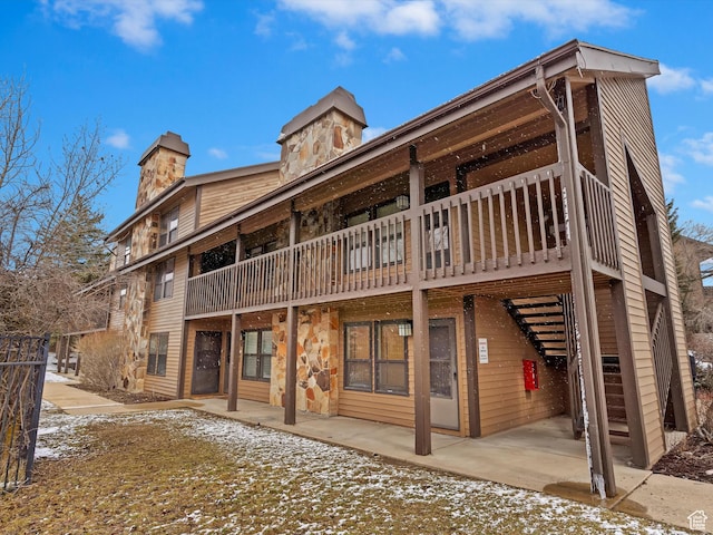 3615 N Wolf Lodge Dr E Unit 109, Eden, UT 84310 - exterior space featuring stairs, a chimney, stone siding, and a patio