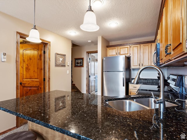 3615 N Wolf Lodge Dr E Unit 109, Eden, UT 84310 - kitchen with dark stone counters, decorative light fixtures, a sink, and stainless steel appliances