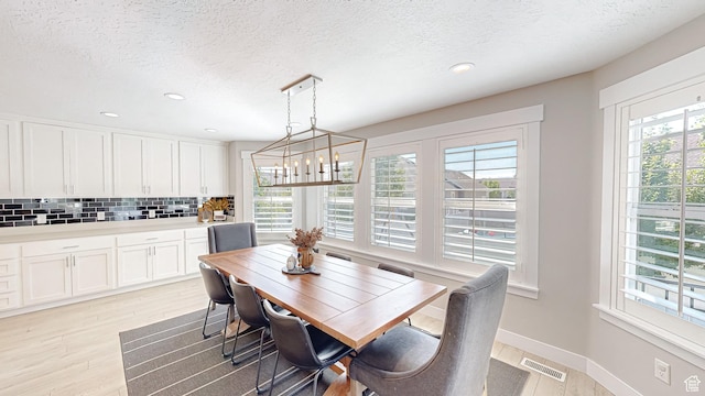 452 S 2500 E Unit 122, Spanish Fork, UT 84660 - dining room with a notable chandelier, light wood finished floors, a textured ceiling, baseboards, and visible vents