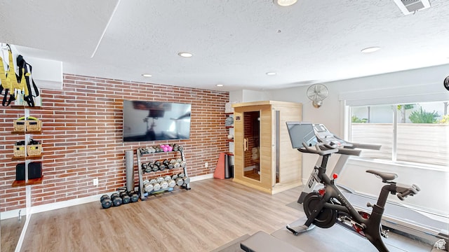 452 S 2500 E Unit 122, Spanish Fork, UT 84660 - exercise room featuring visible vents, wood finished floors, brick wall, and a textured ceiling