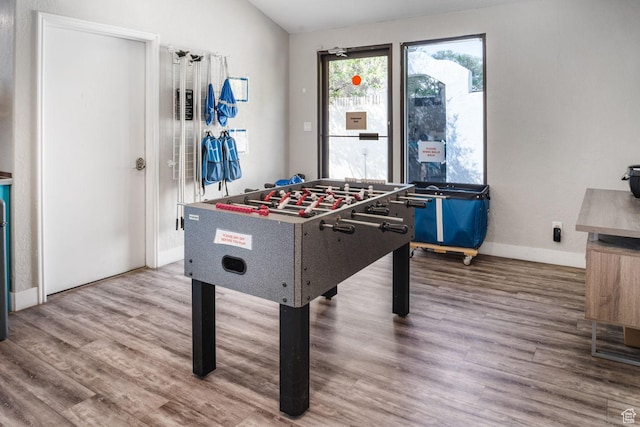 rec room with baseboards, lofted ceiling, and wood finished floors