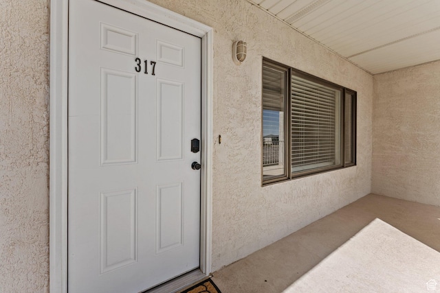 entrance to property with stucco siding